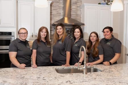 Six of the house cleaners from Vetter Cleaners of Colorado Springs posing for a picture in a freshly cleaned kitchen