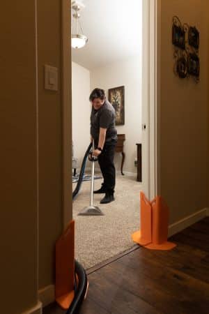 maid from Vetter Cleaners of Colorado Springs vacuuming a carpet