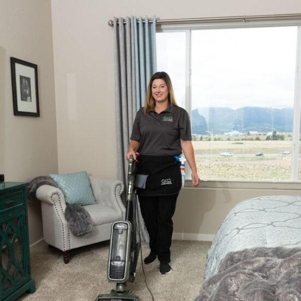 A professional Housekeeper Vacuuming A Bedroom. floor
