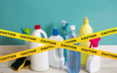 Cleaning products on top of a table with a caution band crossing them.